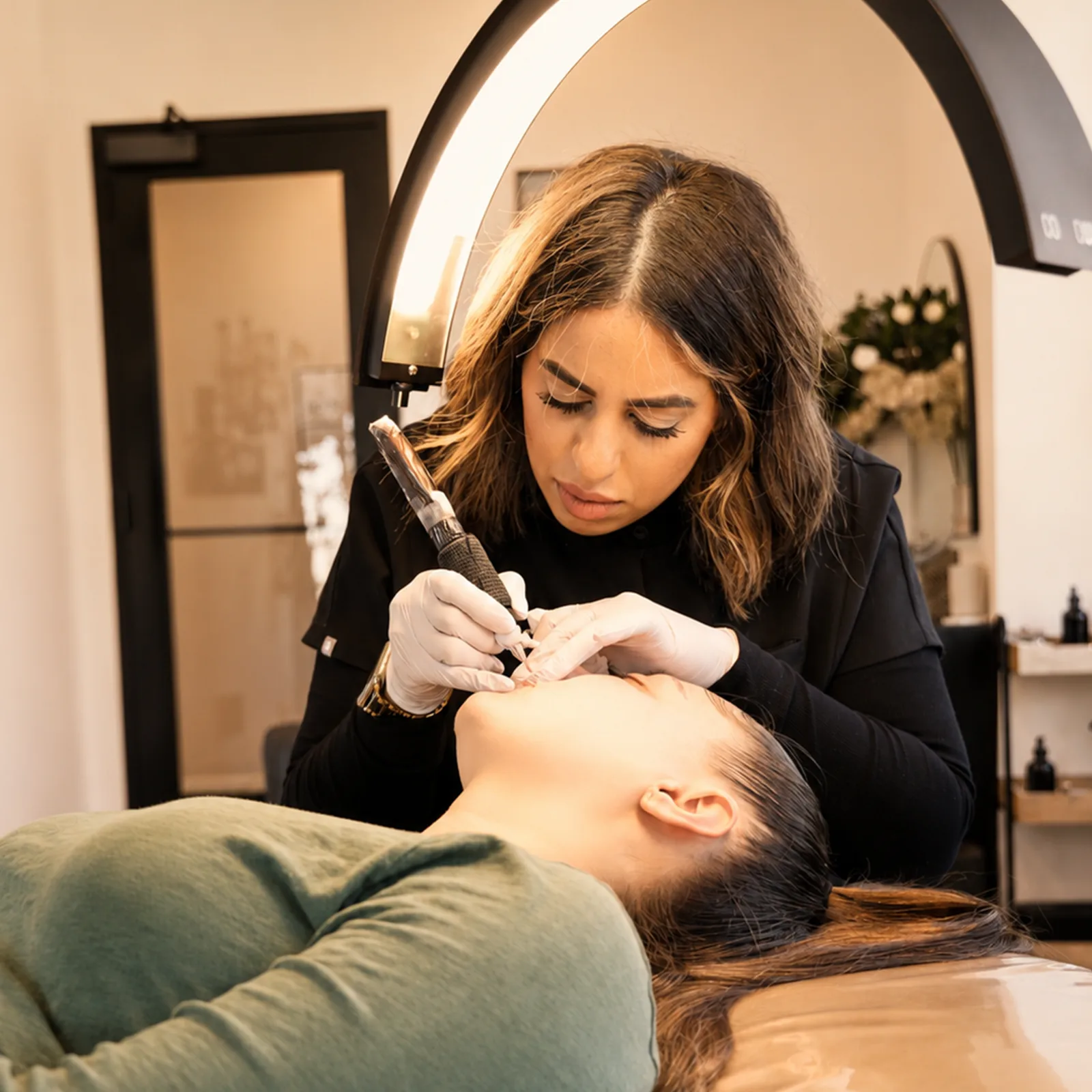 `Brow Studio artist performing a precision permanent makeup treatment in a luxury Milwaukee beauty studio